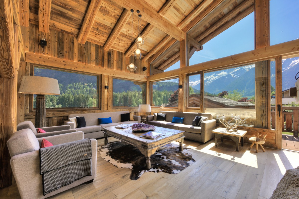 Chalet Des Cristaux’s bay windows – pictured the spacious living room – let in an abundance of light and allow guests the most stunning views of the Mont Blanc and Fiz mountain ranges Chalet Des Cristaux’s bay windows – pictured the spacious living room – let in an abundance of light and allow guests the most stunning views of the Mont Blanc and Fiz mountain ranges