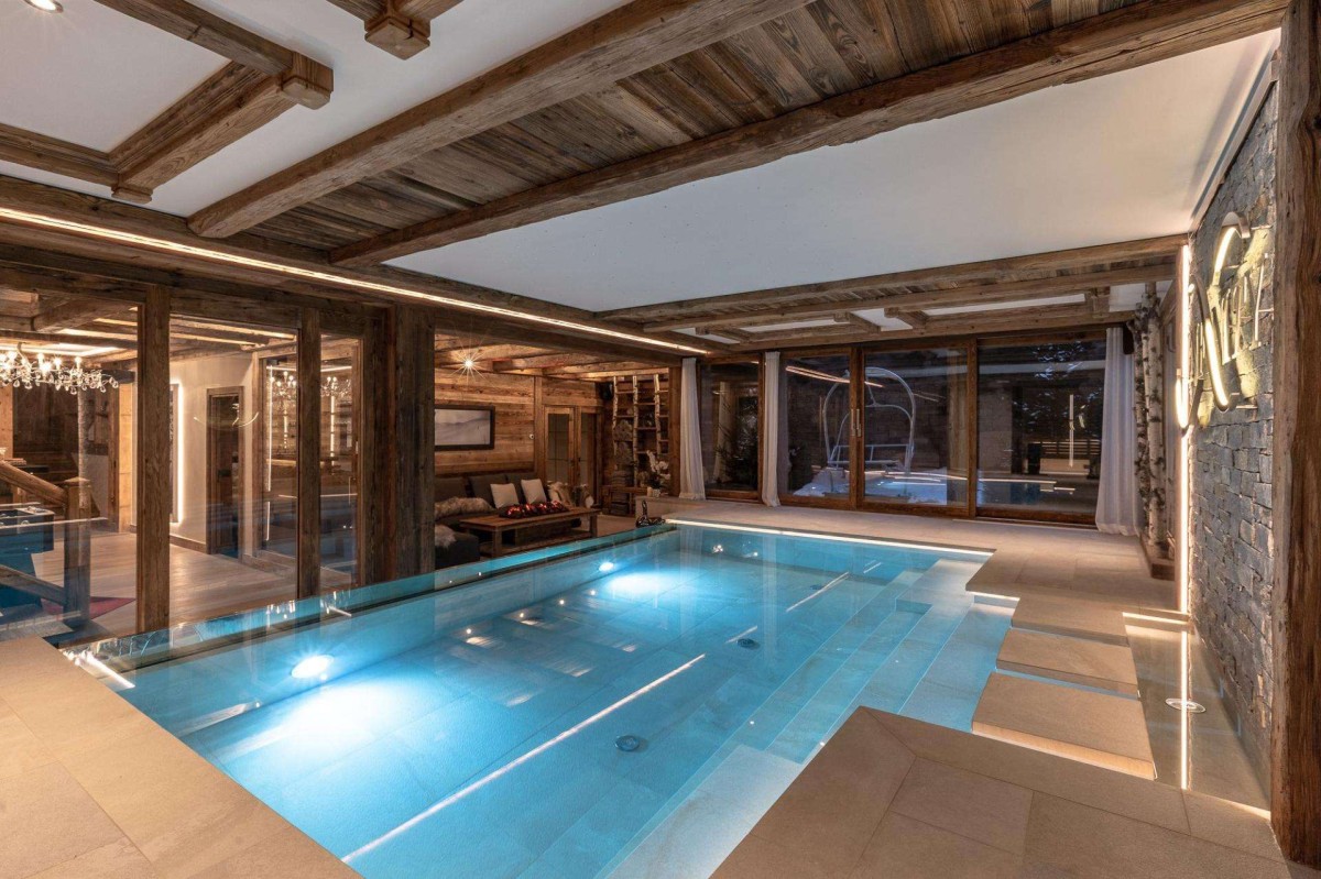 Chalet Infinity’s relaxation area features the large swimming pool with jet stream, massage room, bar, sauna, Hammam, gym and cinema room. The open plan living room faces the pool