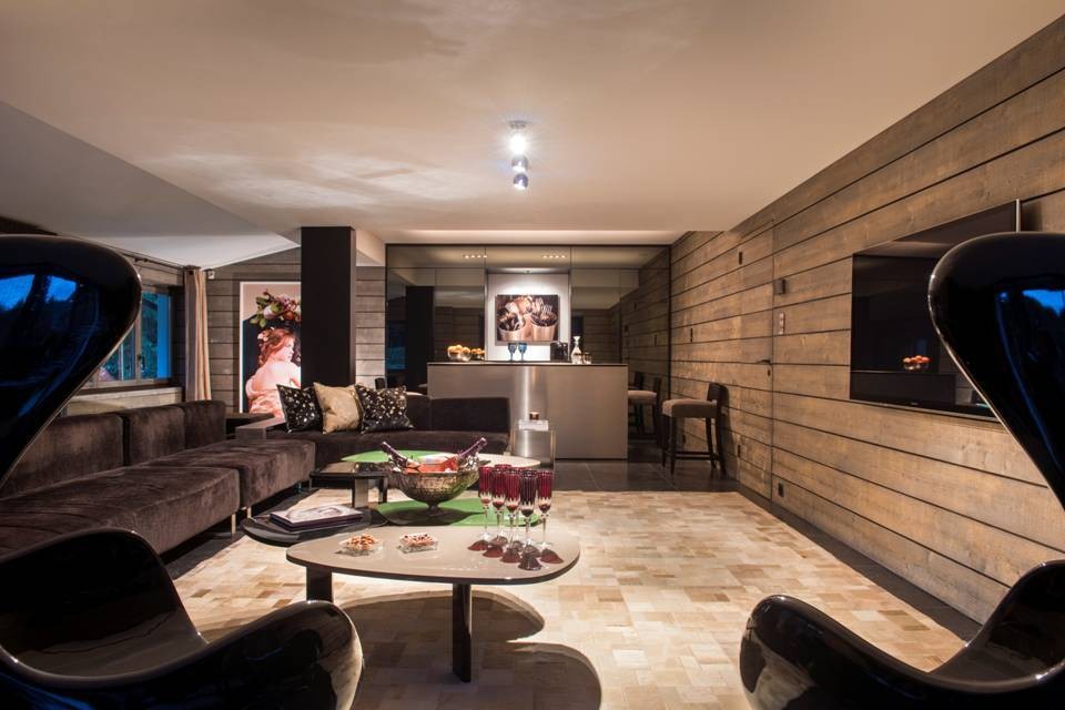Chalet Aflabim, Gstaad, Swiss Alps – after a day on the slopes guests can lounge and relax in the entertainment room on the ground floor with it’s big TV screen and bar Chalet Aflabim, Gstaad, Swiss Alps – after a day on the slopes guests can lounge and relax in the entertainment room on the ground floor with it’s big TV screen and bar