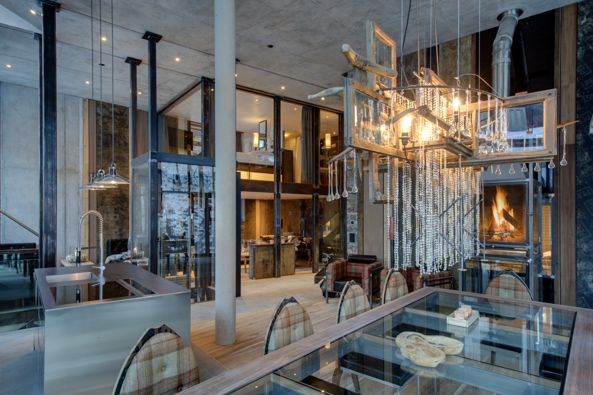 Backstage Luxury Loft in Zermatt – the dining area with the open fire in the backgroundDon’t miss the Heinz Julen Loft  in Zermatt! This marvellous property sleeps up to 6 guests